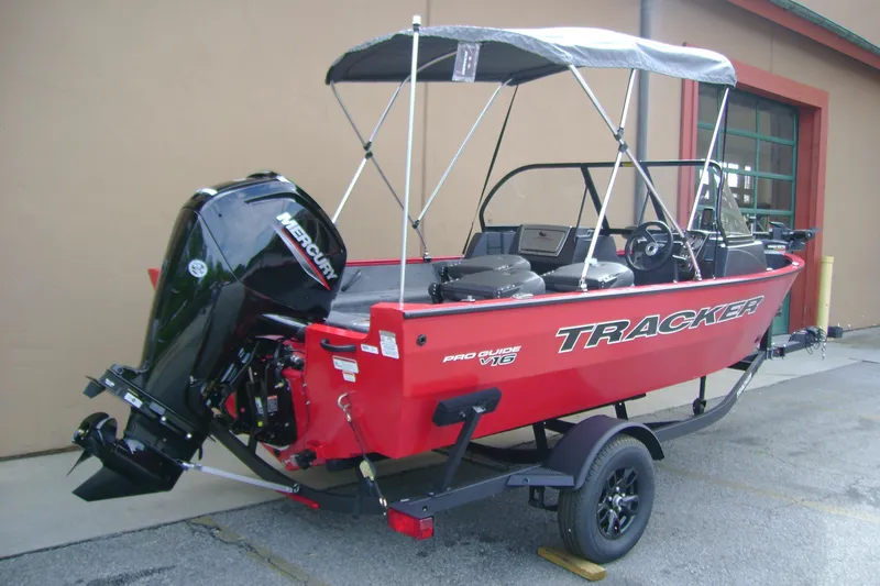 Slide: The Image of 2026 Tracker Pro Guide V-16 WT boat with Mercury outboard motor, parked on trailer. - 2