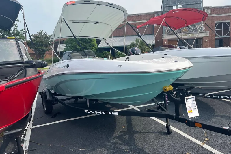 Slide: The Image of 2026 Tahoe T16 boat on trailer, displayed outdoors with canopy. - 1