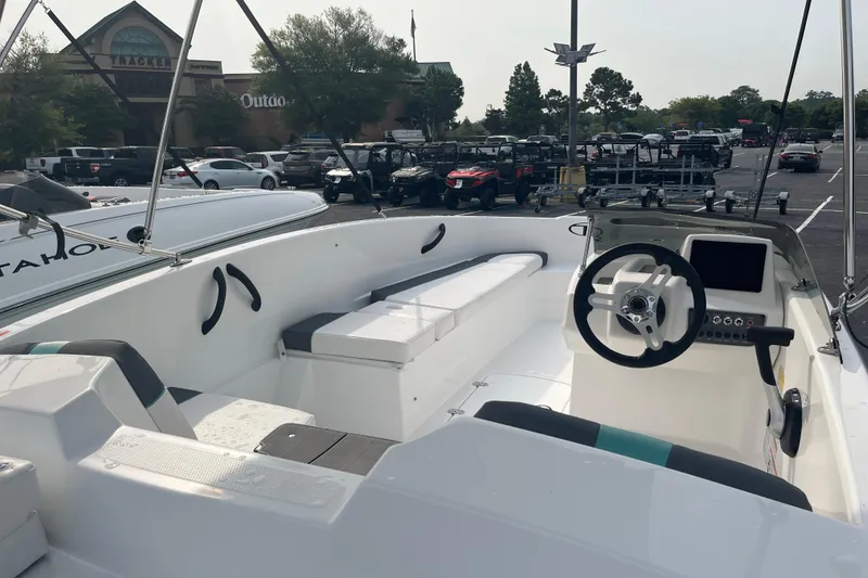Slide: The Image of 2026 Tahoe T16 boat interior with steering wheel and seating, parked outdoors. - 7