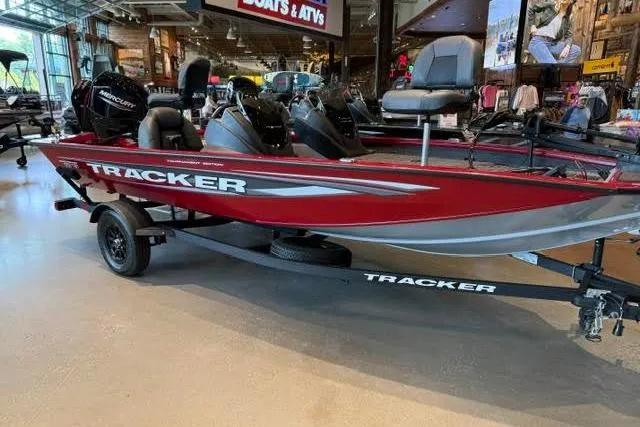 The Image of 2026 Tracker Pro Team 175 boat displayed in a showroom, featuring a sleek red design. - 0
