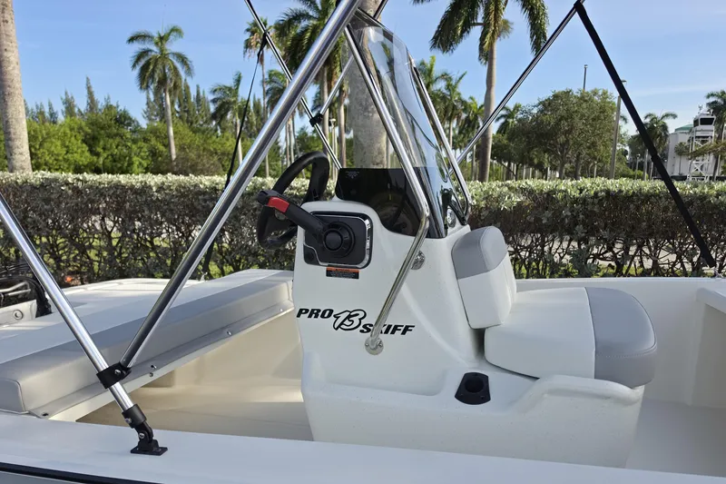 Slide: The Image of 2026 Mako Pro Skiff 13 CC boat interior with steering console and seating. - 3