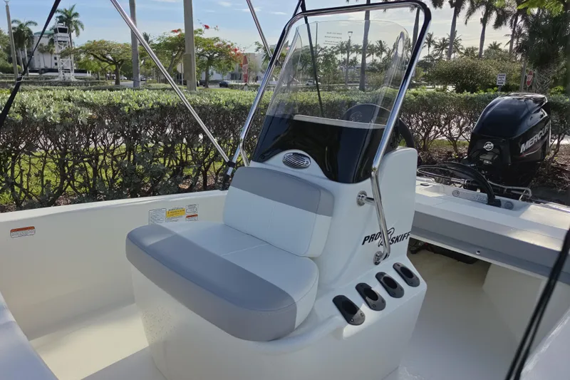 Slide: The Image of 2026 Mako Pro Skiff 13 CC boat with seating and console, parked outdoors. - 5