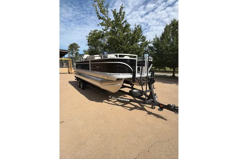 The Image of 2026 Sun Tracker Fishin' Barge 22 DLX pontoon boat on trailer, parked outdoors. - 89