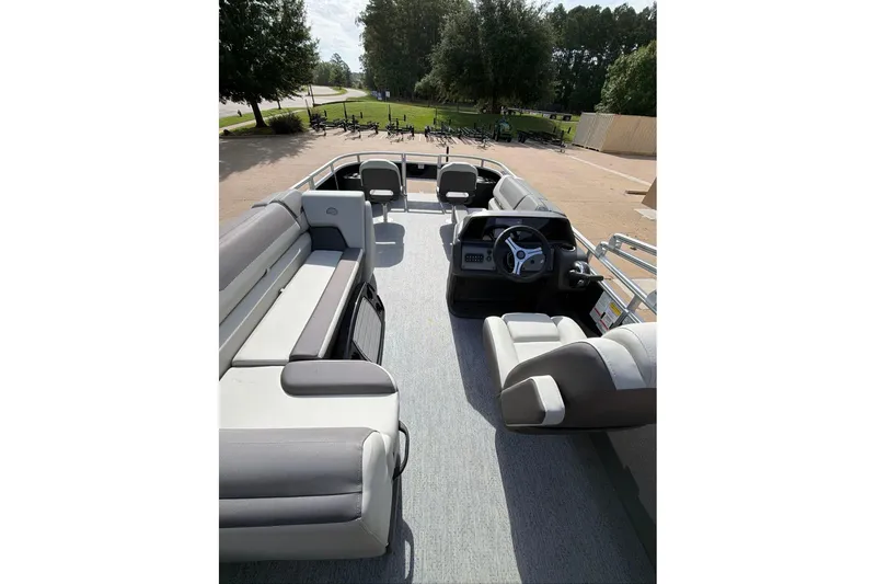 Slide: The Image of 2026 Sun Tracker Fishin' Barge 22 DLX interior with spacious seating and steering console. - 97