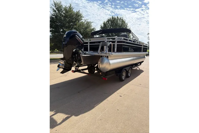Slide: The Image of 2026 Sun Tracker Fishin' Barge 22 DLX pontoon boat on trailer, parked outdoors. - 91