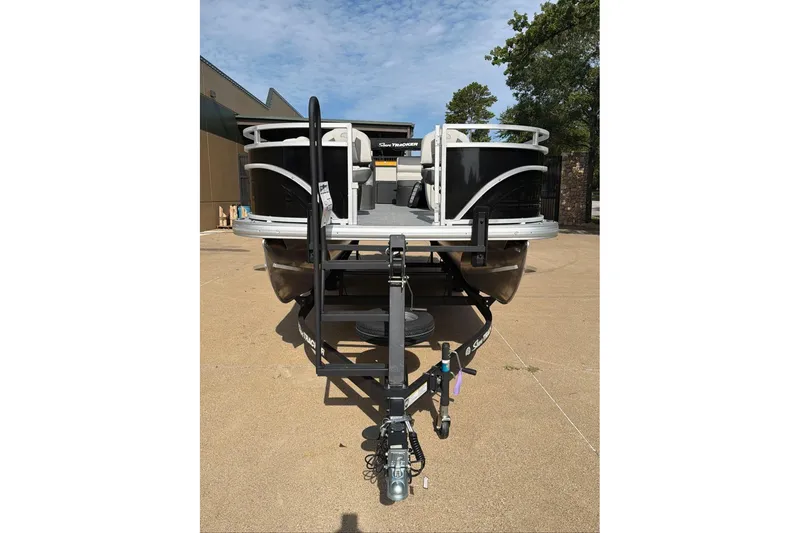 Slide: The Image of 2026 Sun Tracker Fishin' Barge 22 DLX pontoon boat on trailer, outdoor setting. - 96