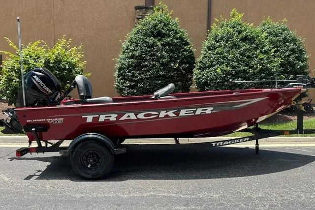 The Image of 2026 Tracker Super Guide V-16 T boat on trailer, red color, parked outdoors. - 0