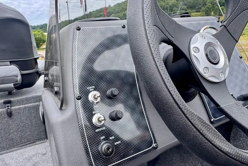 Slide: The Image of 2026 Tracker Bass Tracker Classic XL dashboard with steering wheel and control switches. - 13