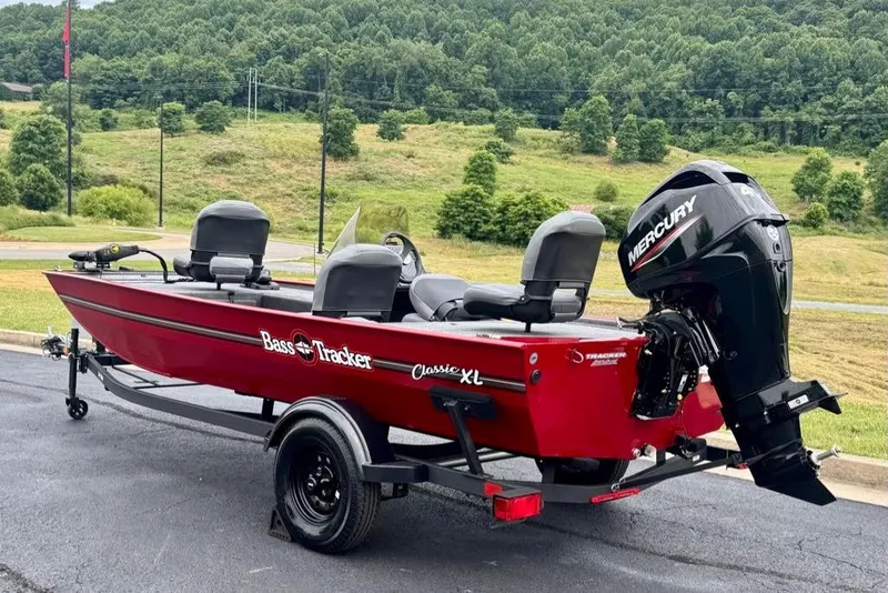 Slide: The Image of 2026 Tracker Bass Tracker Classic XL boat with Mercury engine, parked outdoors. - 5
