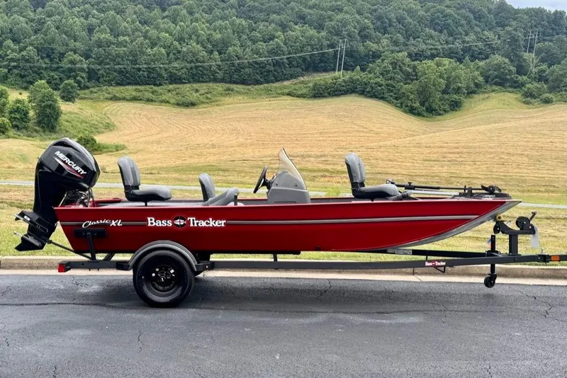 The Image of 2026 Tracker Bass Tracker Classic XL boat on trailer, set against a scenic countryside backdrop. - 0