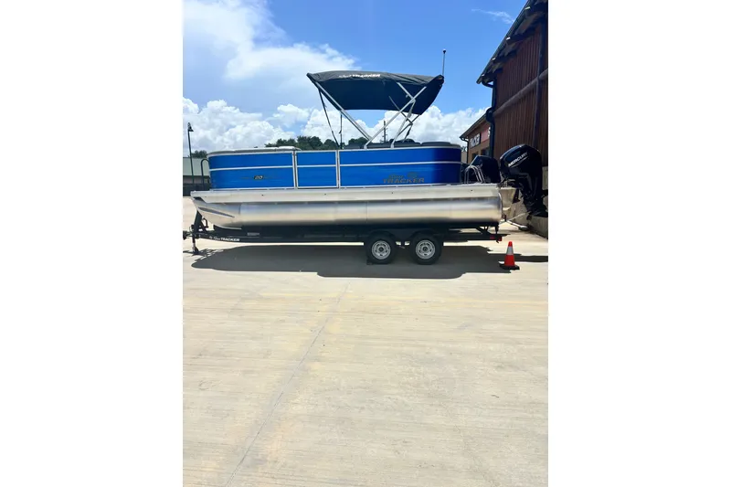 The Image of 2026 Sun Tracker Party Barge 20 DLX pontoon boat on trailer, parked outdoors. - 0