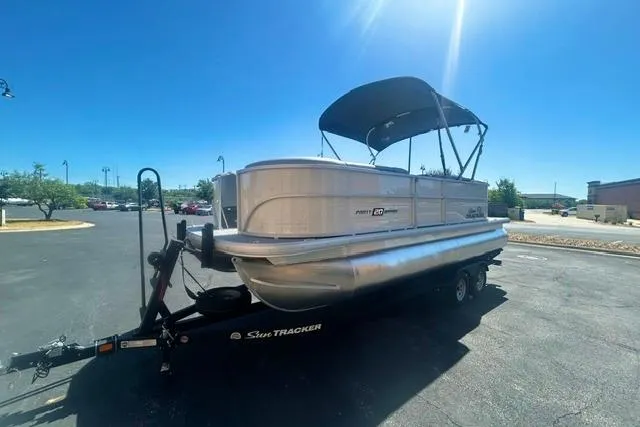 Slide: The Image of 2026 Sun Tracker Party Barge 20 DLX pontoon boat on trailer in parking lot. - 2