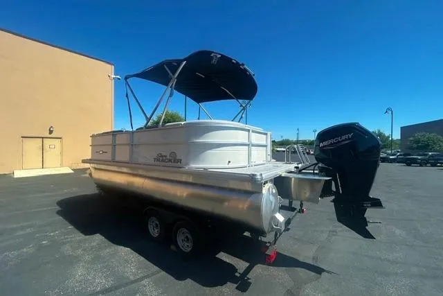 Slide: The Image of 2026 Sun Tracker Party Barge 20 DLX pontoon boat with Mercury outboard motor in parking lot. - 3