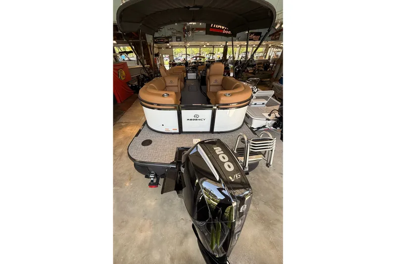 Slide: The Image of 2026 Regency 230 DL pontoon boat with Mercury 200 V6 engine in a showroom. - 1