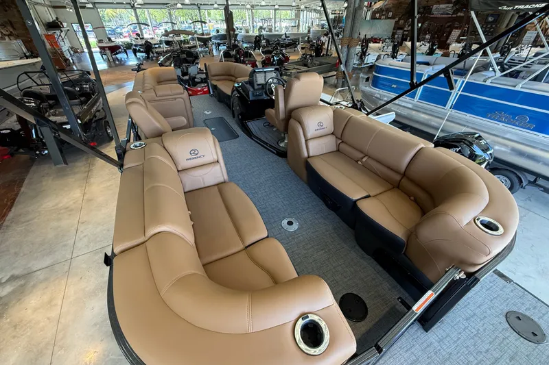 Slide: The Image of Luxurious 2026 Regency 230 DL pontoon boat with spacious tan seating in showroom. - 3