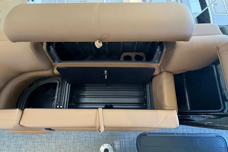 Slide: The Image of Open storage compartment in 2026 Regency 230 DL boat with tan upholstery. - 9