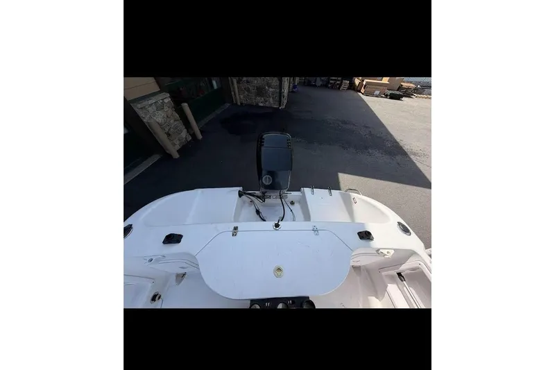 Slide: The Image of 2002 Pro-Line 19 Sport boat with outboard motor, parked outdoors. - 4