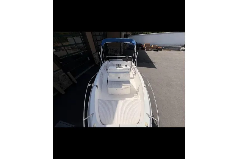 Slide: The Image of 2002 Pro-Line 19 Sport boat with blue canopy, docked outdoors. - 5
