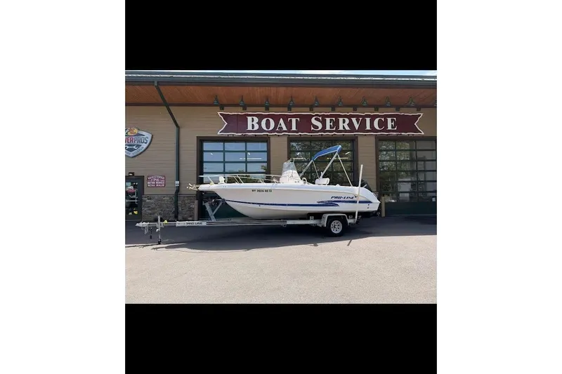 Slide: The Image of 2002 Pro-Line 19 Sport boat on trailer outside boat service center. - 9