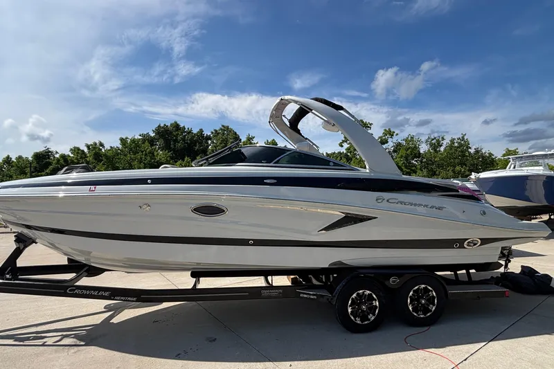 Slide: The Image of 2020 Crownline 290 SS boat on trailer under clear blue sky. - 1