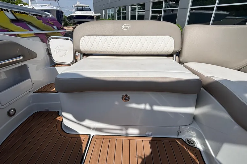 Slide: The Image of 2020 Crownline 290 SS boat interior with cushioned seating and wood-style flooring. - 11