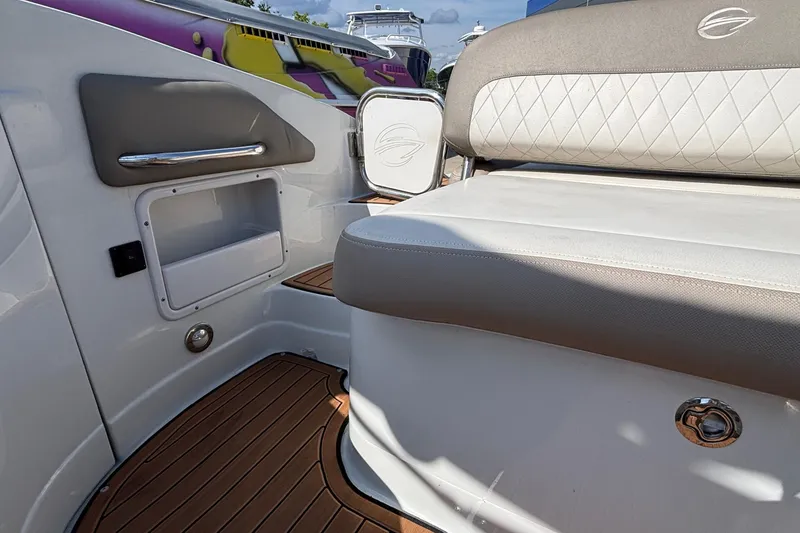 Slide: The Image of 2020 Crownline 290 SS boat interior with cushioned seating and wood flooring. - 12