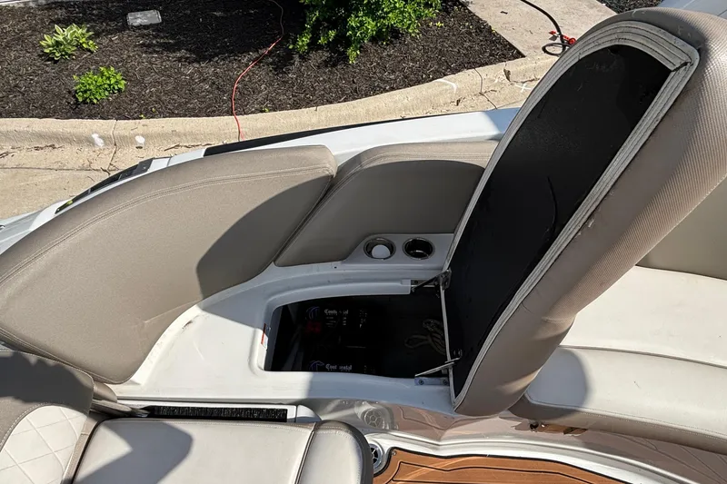 Slide: The Image of Open storage compartment on a 2020 Crownline 290 SS boat with beige seating. - 19