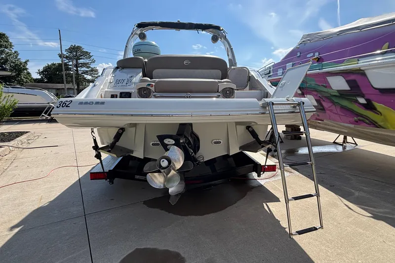 Slide: The Image of 2020 Crownline 290 SS boat with ladder and dual propellers, docked outdoors. - 2