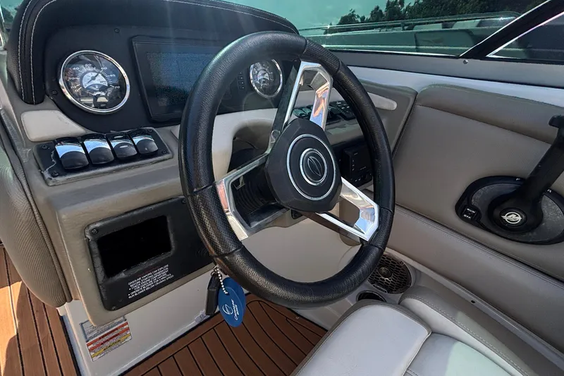 Slide: The Image of Steering wheel and dashboard of 2020 Crownline 290 SS boat, featuring gauges and controls. - 24