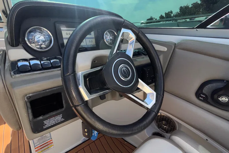 Slide: The Image of Steering wheel and dashboard of 2020 Crownline 290 SS boat, featuring modern controls. - 32
