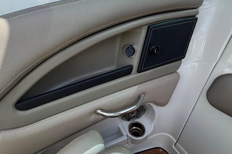 Slide: The Image of Interior detail of 2020 Crownline 290 SS boat, featuring storage compartment and cup holder. - 34