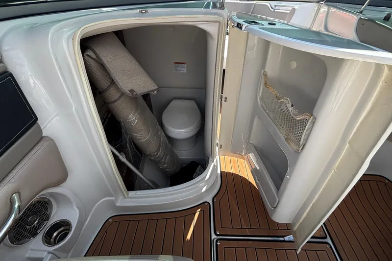 Slide: The Image of 2020 Crownline 290 SS boat interior with compact bathroom and wooden flooring. - 35