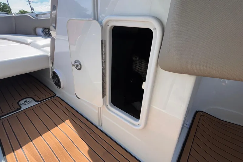 Slide: The Image of 2020 Crownline 290 SS boat interior with open storage compartment and teak flooring. - 38