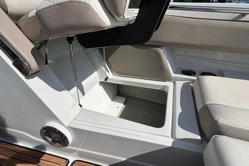 Slide: The Image of 2020 Crownline 290 SS boat interior storage compartment with cushioned seating and speaker. - 48