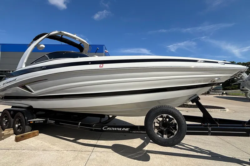 Slide: The Image of 2020 Crownline 290 SS boat on trailer under clear blue sky. - 58