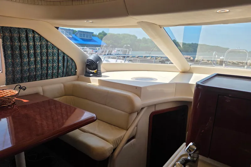 Slide: The Image of Interior of 2002 Sea Ray 560 Sedan Bridge yacht with plush seating and scenic window view. - 119