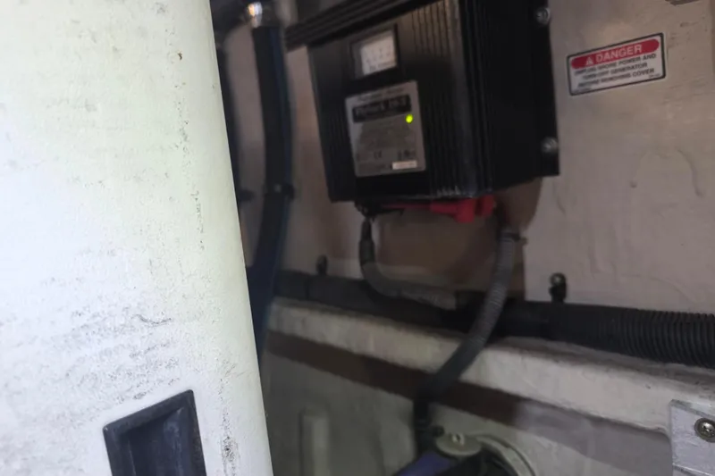 Slide: The Image of Engine room of 2002 Sea Ray 560 Sedan Bridge with electrical components and warning label. - 125