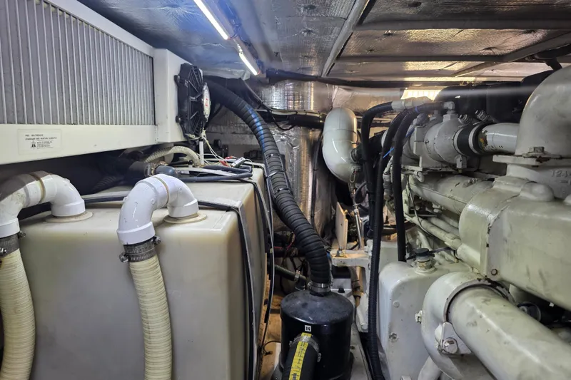 Slide: The Image of Engine room of a 2002 Sea Ray 560 Sedan Bridge, showcasing machinery and piping. - 131