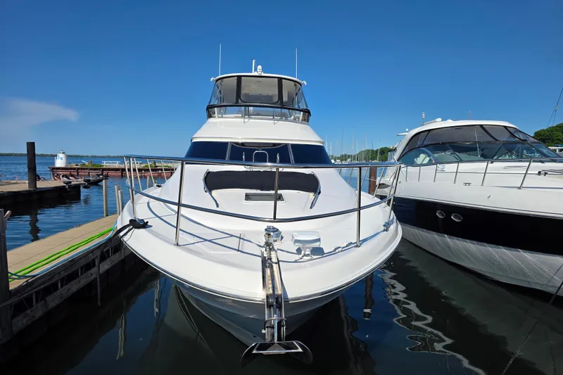 Slide: The Image of 2002 Sea Ray 560 Sedan Bridge yacht docked at marina under clear blue sky. - 21