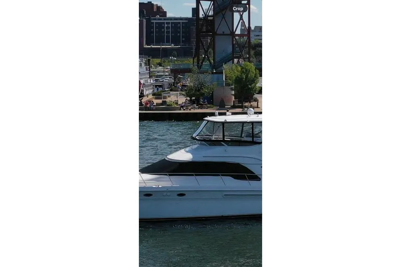 Slide: The Image of 2002 Sea Ray 560 Sedan Bridge yacht cruising near urban waterfront. - 30