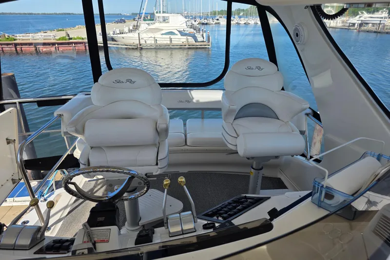 Slide: The Image of Interior view of 2002 Sea Ray 560 Sedan Bridge yacht with white captain chairs. - 42