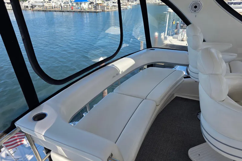 Slide: The Image of Luxurious interior of 2002 Sea Ray 560 Sedan Bridge yacht with white seating and marina view. - 45