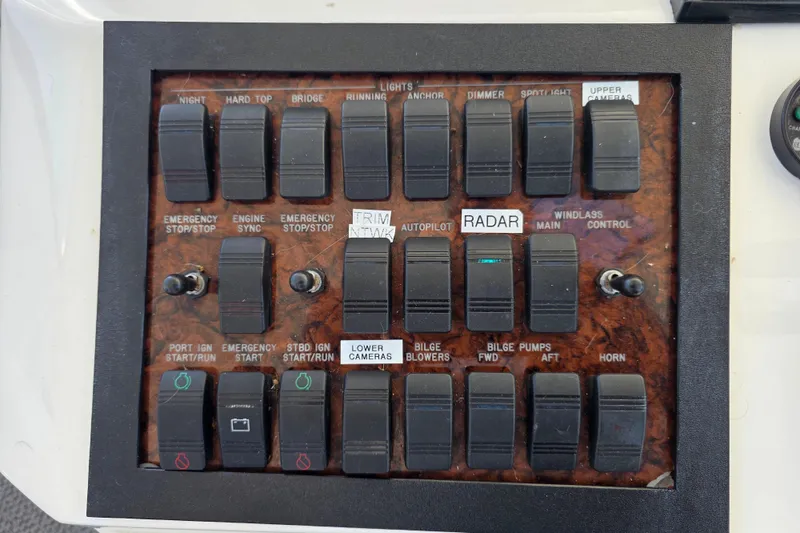 Slide: The Image of Control panel of a 2002 Sea Ray 560 Sedan Bridge with labeled switches and toggles. - 52