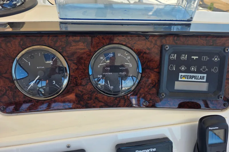 Slide: The Image of Dashboard of a 2002 Sea Ray 560 Sedan Bridge with gauges and Caterpillar display. - 56