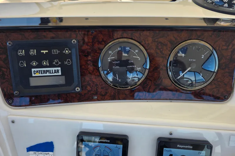 Slide: The Image of Dashboard of a 2002 Sea Ray 560 Sedan Bridge with Caterpillar controls and gauges. - 57