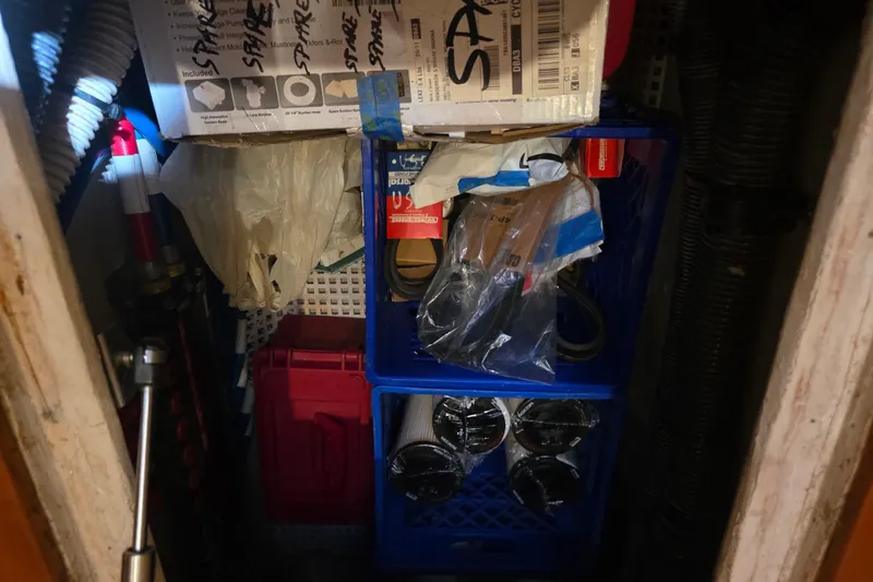 Slide: The Image of Storage compartment on a 2002 Sea Ray 560 Sedan Bridge with spare parts and tools. - 93