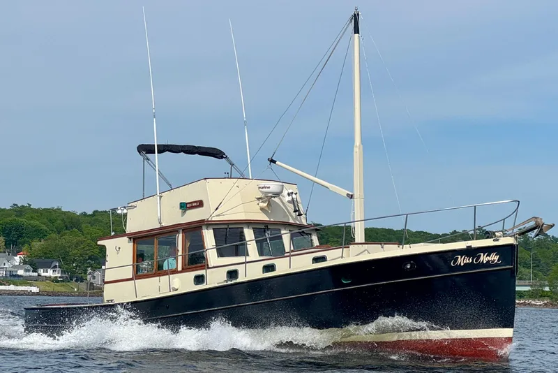 The Image of 1976 Downeast Flybridge Cruiser navigating water, showcasing classic design and elegance. - 0