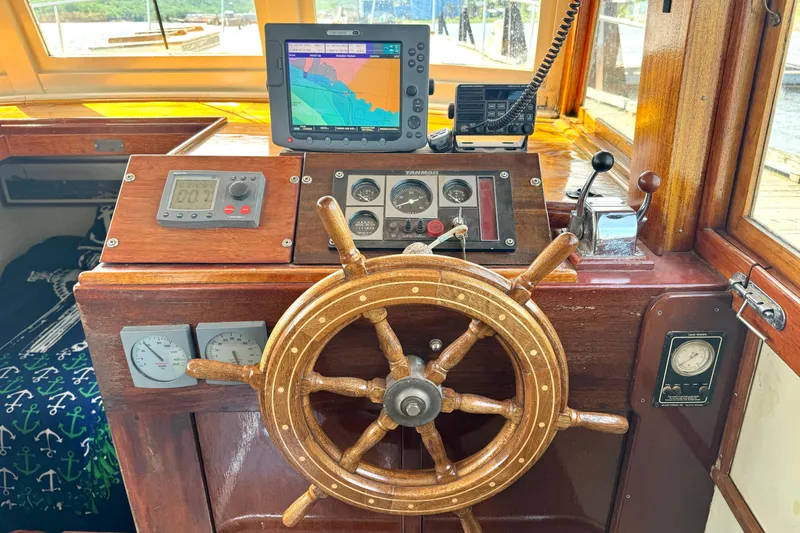 Slide: The Image of 1976 Downeast Flybridge Cruiser helm with wooden wheel and navigation instruments. - 12