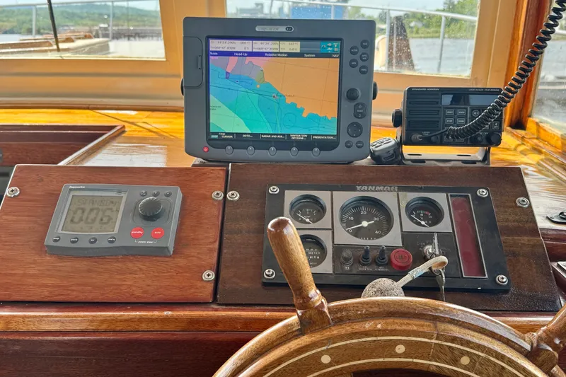 Slide: The Image of Helm of 1976 Downeast Flybridge Cruiser with navigation equipment and wooden steering wheel. - 13