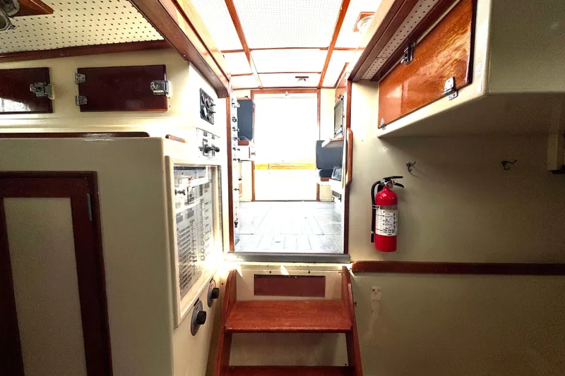 Slide: The Image of Interior of a 1976 Downeast Flybridge Cruiser with wooden cabinetry and a fire extinguisher. - 15